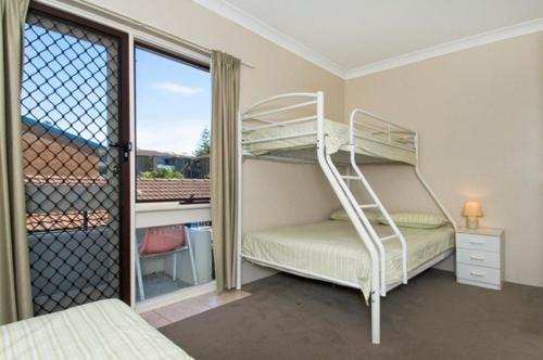 a bedroom with a bunk bed and a balcony at Bay Park Gardens 30 1 Warlters Street in Port Macquarie