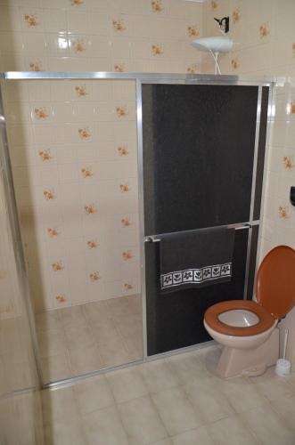 a bathroom with a toilet and a black screen at Cantinho do Canaã in Arraial do Cabo