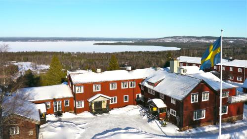 a building with a flag on top of it in the snow at Hotell Villa Långbers in Tällberg
