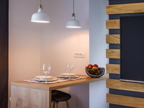 a table with two wine glasses and a bowl of fruit at Apartments Withlove Zadar in Zadar