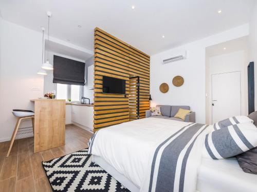 a bedroom with a large bed and a kitchen at Apartments Withlove Zadar in Zadar