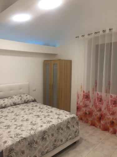 ヴェンティミリアにあるappartamento rocchettaのベッドルーム1室(ベッド1台付)、木製キャビネットが備わります。