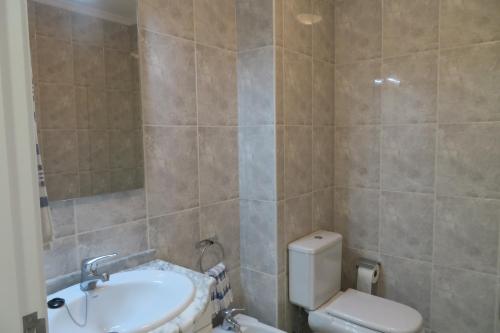 a bathroom with a white toilet and a sink at Lenda do Mar in Vila Chã