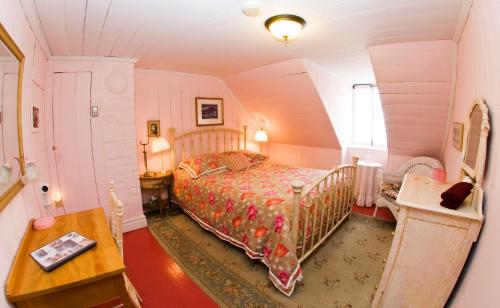 a bedroom with a bed and a table in a room at Maison Hovington in Tadoussac