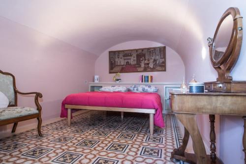 a bedroom with a pink bed and a mirror at Casa Katy in Siena