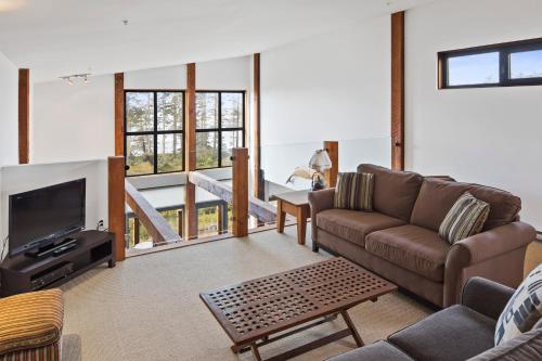 a living room with a couch and a tv at Black Rock Ridge in Ucluelet