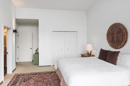 a bedroom with a large white bed and a rug at Black Rock Ridge in Ucluelet