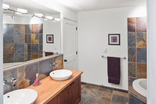 a bathroom with two sinks and a large mirror at Black Rock Ridge in Ucluelet