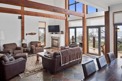 a living room with leather furniture and a tv at Black Rock Ridge in Ucluelet