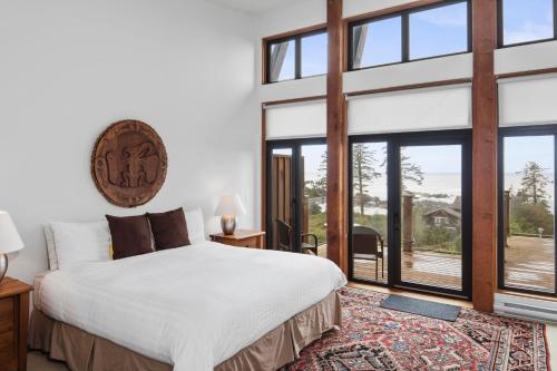 a bedroom with a large bed and large windows at Black Rock Ridge in Ucluelet