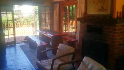 un soggiorno con camino, tavolo e sedie di Chalet Bosque Peralta Ramos a Mar del Plata
