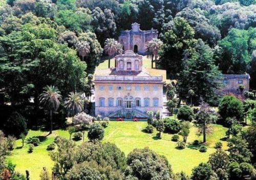 a large building on top of a lush green field at Villa di Corliano Relais all'Ussero in San Giuliano Terme