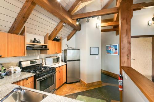 a kitchen with wooden cabinets and a stainless steel refrigerator at Black Rock Landing in Ucluelet