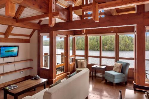 a living room with a couch and chairs and windows at Black Rock Landing in Ucluelet
