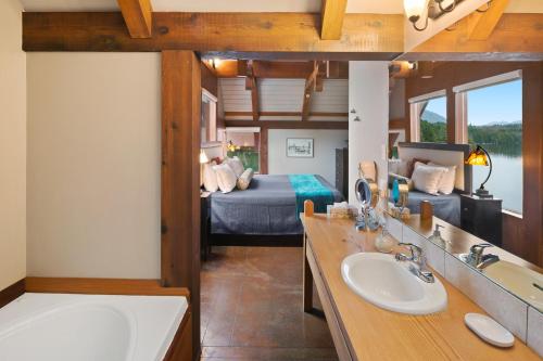 a bathroom with a tub and a bedroom with a bed at Black Rock Landing in Ucluelet
