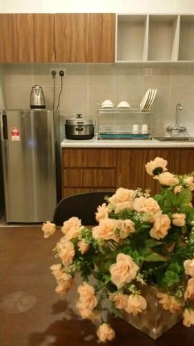 a kitchen with a table with a bunch of flowers at Golden Hill 1 Room Apt at Night Market in Cameron Highlands