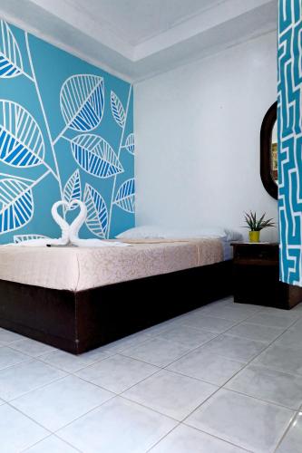 a bedroom with a bed with a blue wall at Island Inn in Boracay