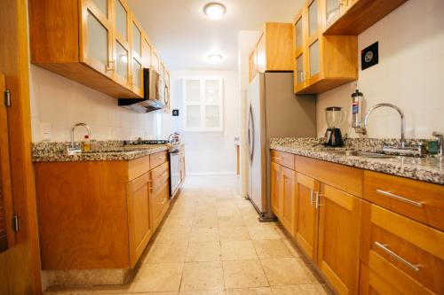 a kitchen with wooden cabinets and a tile floor at The Gallery in Mexico City