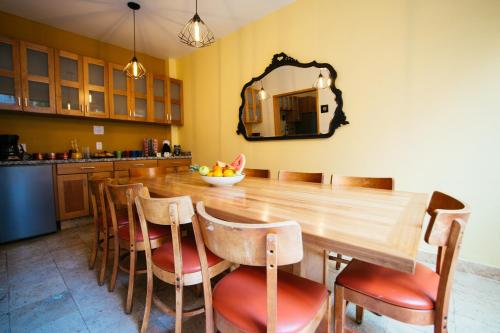 a kitchen with a wooden table with chairs and a mirror at The Gallery in Mexico City