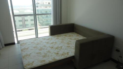 a couch in a room with a large window at Prainha Aconchegante apto de quarto e sala com vista para o mar in Arraial do Cabo