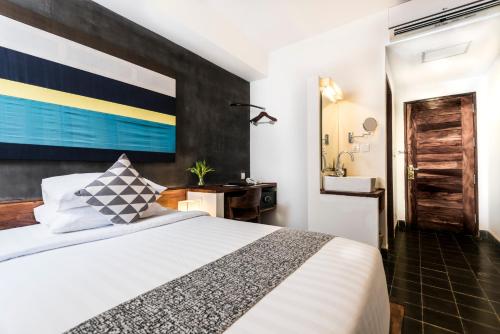 a hotel room with a bed and a bathroom at PATIO Hotel & Urban Resort in Phnom Penh