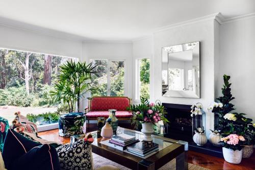 
a living room filled with furniture and plants at Beechmont Garden Retreat in Olinda
