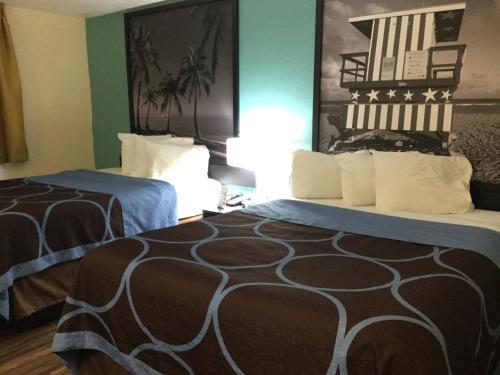 a hotel room with two beds and green walls at Super8 by Wyndham NEARBY Clearwater St Petersburg International Airport in Clearwater