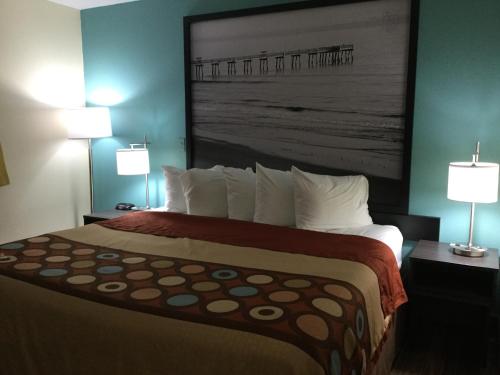 a hotel room with a large bed with two lamps at Super8 by Wyndham NEARBY Clearwater St Petersburg International Airport in Clearwater