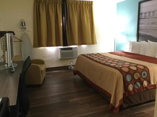 a hotel room with a bed and a window at Super8 by Wyndham NEARBY Clearwater St Petersburg International Airport in Clearwater