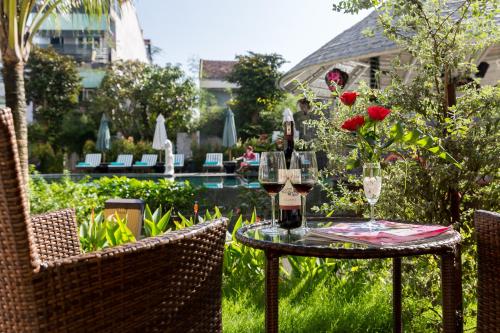 a table with wine glasses and roses on it at Hoi An Emotion Boutique Villa in Hoi An