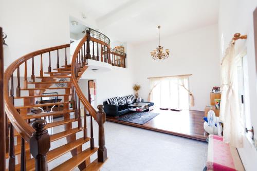 a living room with a staircase and a couch at Alice Springs Homestay in Tianfu