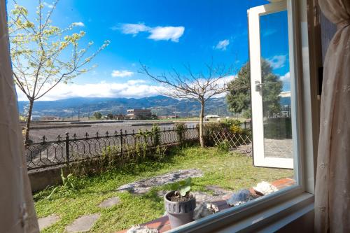 a window with a view of a river and mountains at Alice Springs Homestay in Tianfu