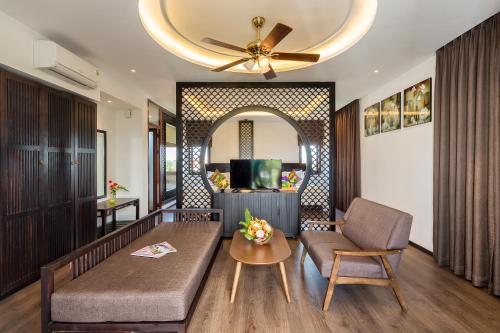 a living room with a couch and a table at Hoi An Emotion Boutique Villa in Hoi An