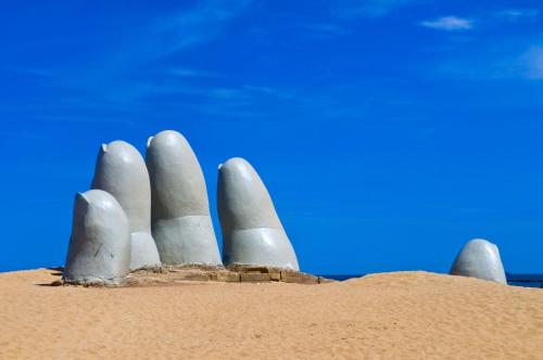 a sand sculpture of three fingers in the desert at Hotel Sunset Beach in Punta del Este