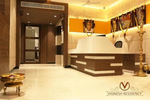 a lobby with a white counter in a building at Vignesh Residency in Tiruchchirāppalli