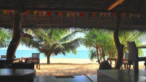 a view of a beach with palm trees and the ocean at Mangrove Beach Cabana in Tangalle