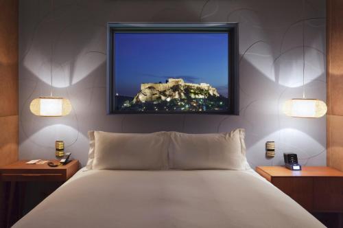 a bedroom with a bed and a tv on the wall at New Hotel, a Member of Design Hotels in Athens