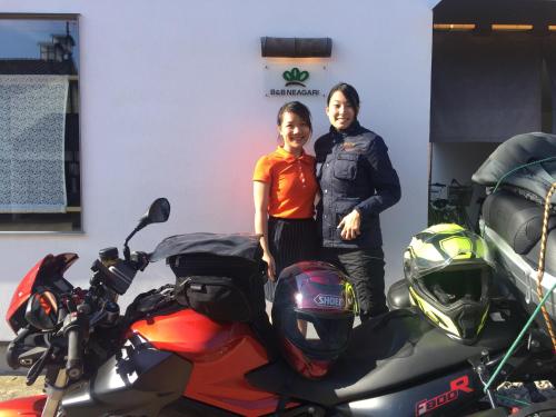 a man and a woman standing next to a motorcycle at B&B Neagari in Nomi