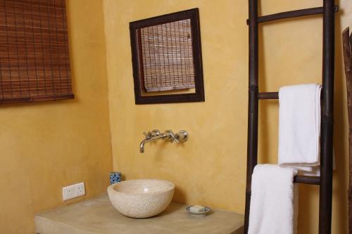 a bathroom with a bowl sink on a counter at La Hacienda Mauritius in Mahébourg