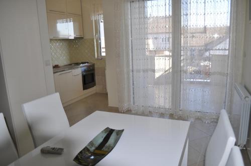 a kitchen with a white table and a window at Apartments Soleado in Pančevo
