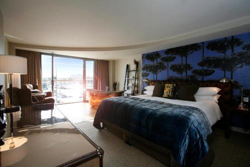 a bedroom with a large bed with a blue wall at Salthouse Harbour Hotel in Ipswich