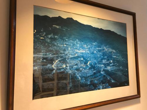 a painting of a city in a frame on a wall at Corner Inn九份住宿I 小角落民宿I 機車租借I日夜間導覽 in Jiufen