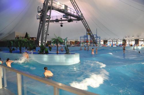 a group of people swimming in a large swimming pool at Wellness Hotel Bešeňová in Bešeňová