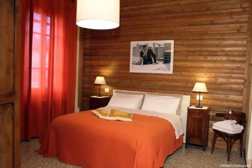 a bedroom with a bed with a wooden wall at La Sosta Fuori Stazione in Brescello