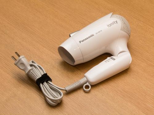 a white hair dryer on a wooden table at HATAGO INN Kansai Airport in Izumi-Sano
