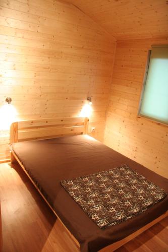a room with a bed in a log cabin at Domki Rybka in Sarbinowo