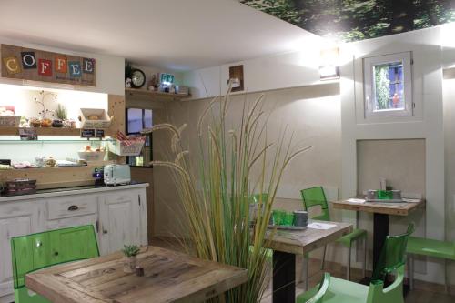 a kitchen with two tables and green chairs at Atipik Hôtel in Annecy