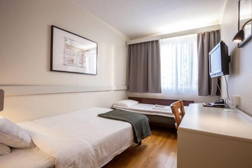 Un pat sau paturi într-o cameră la Pietarsaaren Kaupunginhotelli