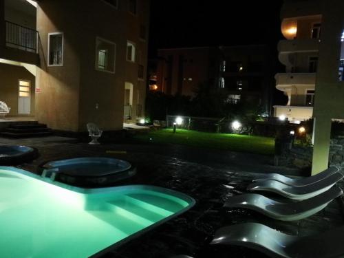 a swimming pool at night with two toilets in it at Rayon Vert Bleuphorie Beach Apartment in Flic-en-Flac