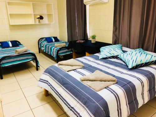 um quarto com duas camas e uma mesa num quarto em Accommodation @ Isa em Mount Isa